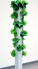 Fototapeta premium Artificial ivy decorates a white pillar indoors