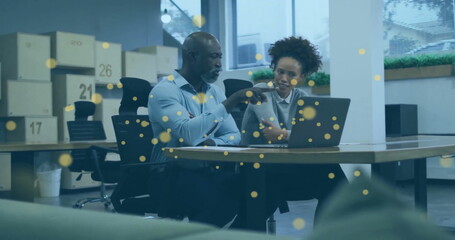 Image of glowing yellow spots over diverse business people in office