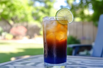 A refreshing butterfly pea flower iced tea with a slice of lime, served in a tall glass on a sunlit patio