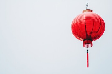 Obraz premium Red Chinese Lantern Hanging Against a Clear Sky