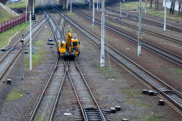 A bright yellow train is steadily traveling down the train tracks