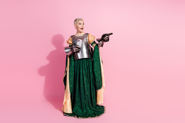 Blonde Woman Dressed as Medieval Knight Holding Smartphone Against Pink Background