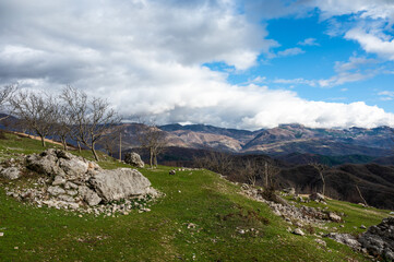 Fallen stone and rock formation with a mountain background at Gamti Mountain, Albania
