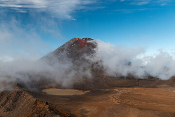 View of volcano Mount Ngauruhoe with fog rolling over the mountain and crystal clear sky (Tongariro Crossing, North Island, New Zealand)