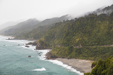 View of western shoreline of Nea Zealand's South Island as seen after a rainshower with crashing waves and rolling clouds (New Zealand)