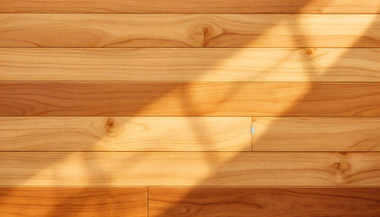 a warm and inviting wooden floor bathed in soft sunlight. The sunlight creates interesting patterns on the surface of the wood, giving the image a natural and cozy feel