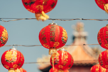 Obraz premium Red Chinese lantern(Translation Hieroglyph text Happy New Year) hanging in a row during day time for Chinese new year celebration.