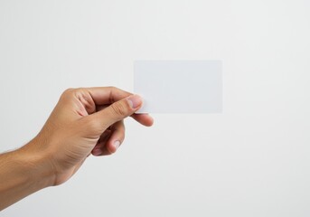 Obraz premium A human hand gently holding a blank white card, symbolizing simplicity and versatility, isolated on a white background