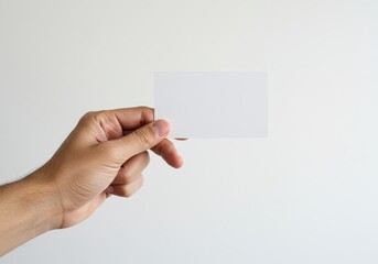 Fototapeta premium A human hand gently holding a blank white card, symbolizing simplicity and versatility, isolated on a white background