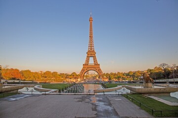 Fototapeta premium Eiffel Tower in Paris glowing in the evening sunlight with fountains