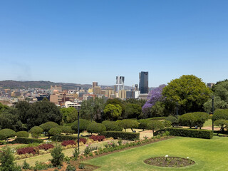Pretoria city view from Union Buildings gardens, high buildings and blooming jacaranda trees. South Africa. © Rawf8
