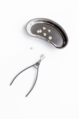 Dental crowns with steel instruments for dental prosthetics, top view. Dentist desk, white background