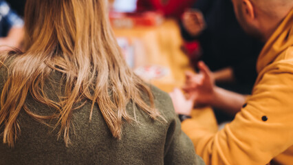 Process of playing tabletop board game on the table, fun with friends and family in room indoors, board game party concept, company group of students adults play board games, roll the dice on game map