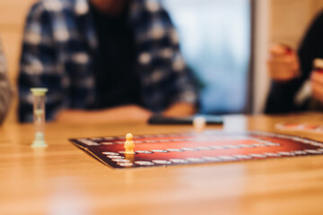Process of playing tabletop board game on the table, fun with friends and family in room indoors,...