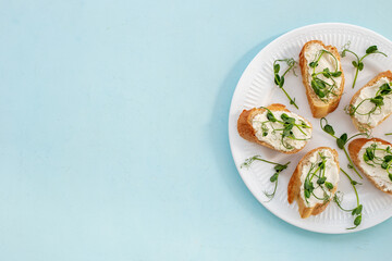 Healthy snack - sandwiches with microgreens on plate, top view
