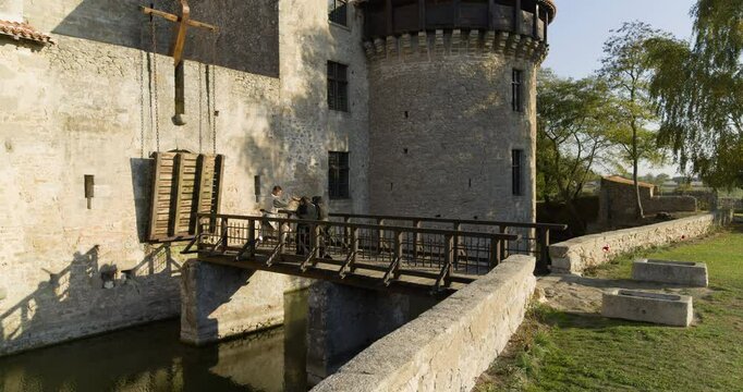 Brave knight fighting off hooded men on bridge of old, medieval castle in France - drone shot