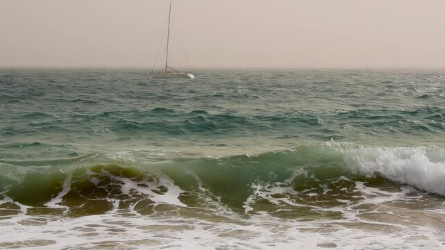 Waves rolling, boat bobbing on the sea. Calima (sahara dust) weather on the Canary Islands.