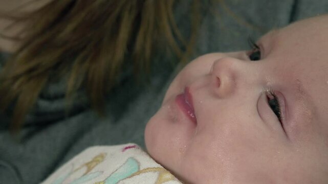 tender mother is olding newborn baby starting eating from a baby bottle