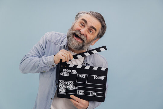 Cheerful Senior Film Director Holding Clapperboard on Set