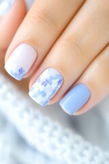 Close-up of elegantly manicured nails featuring soft pastel colors and floral designs, ideal for beauty blogs, nail art tutorials, or advertising nail care products,