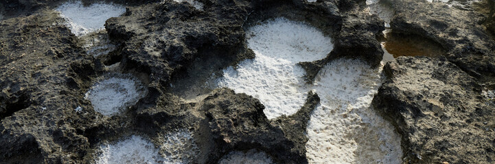 Close-up of natural salt formations in limestone rocks along Monopoli coast. Detail of erosion patterns with crystallized salt deposits