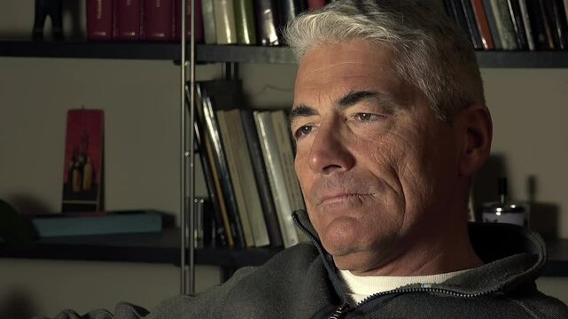 pensive and bored man starts yawning sitting on the sofa at home
