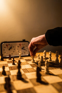 Strategic chess game in progress with a vintage clock