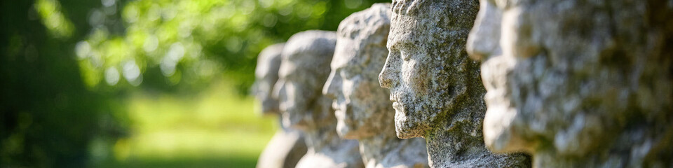 Row of Granite Bust Sculptures in a Garden Setting