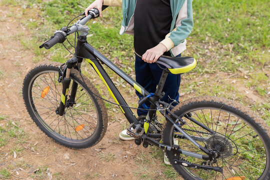 Child with mountain bike on dirt path in park setting