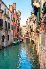 Venice, Italy. View of a narrow canal and boats moored near old houses