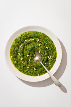 Top view of homemade pesto sauce with pine nuts in a bowl