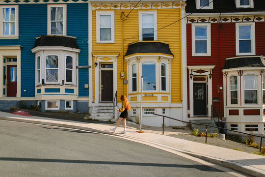Anonymous woman walking past colorful houses in St. John's, Newfoundland