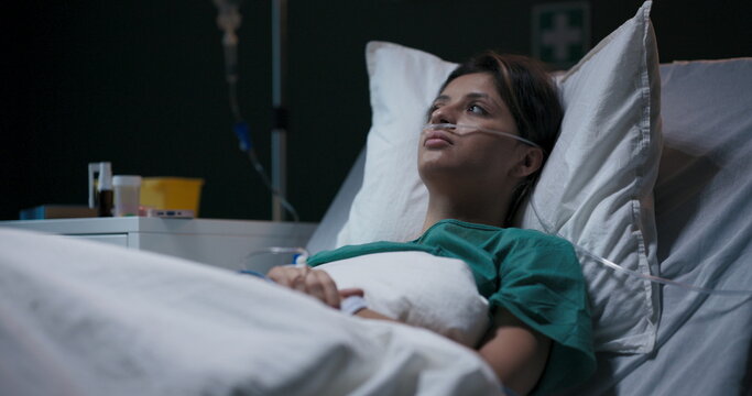Tired and exhausted female patient in hospital ward recovers after bad accdient.