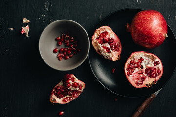 Fresh pomegranates on a dark background.