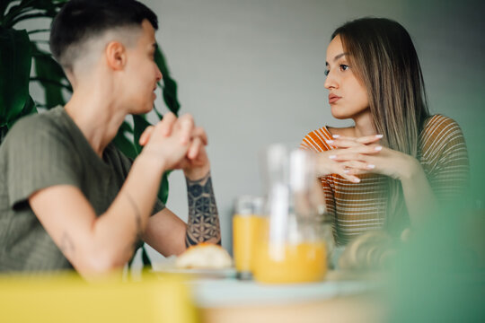 Lesbian couple having a serious conversation during breakfast at home