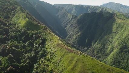 Aerial drone footage captures the breathtaking beauty of a lush green valley nestled between steep,...