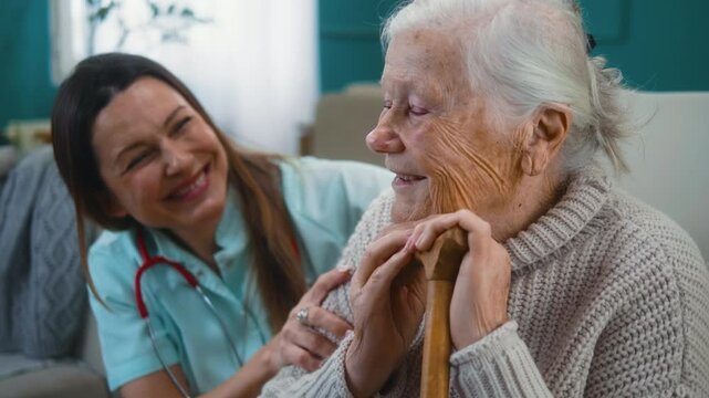Portrait of a carefree elderly 80s woman feeling safe and content while being hugged and caressed by a home caregiver or nurse at home. Support and affection from a nurse or doctor.