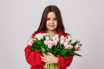 Happy little girl in red dress holds bouquet of white and pink tulips on a white background, copy space. Flower shop advertisement. Mother's day, International women's day concept. High quality photo