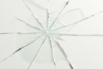 top-down view of cracked frosted glass radiating outward from center with natural lighting and soft shadows