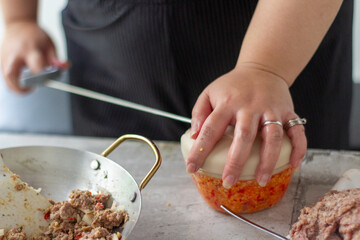 asian woman Hands preparing and shaping minced food mixture in a kitchen. Cooking, food preparation, homemade meal, culinary process.