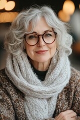 Elegant Mature Woman with Gray Hair and Glasses in Cozy Knitwear Smiling Confidently