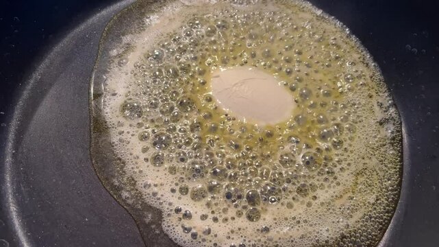 In einer Pfanne schmilzt das Bratfett.