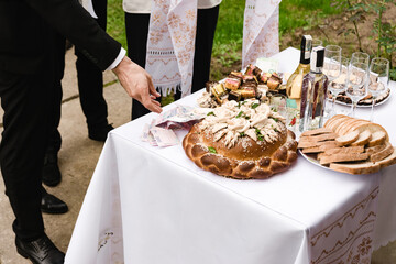 A table laden with a festive loaf, pastries, bread slices, drinks, and cash. It suggests a celebratory event, potentially a wedding or similar cultural ceremony.