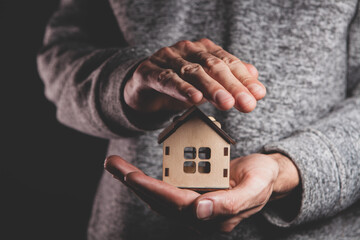 Obraz premium man holding house model with miniature house