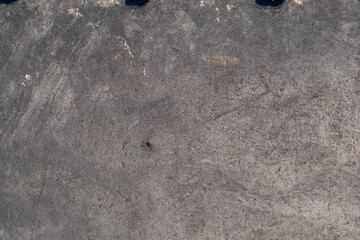 A grey concrete surface with a few black marks on it