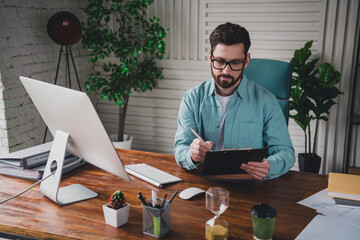 Young professional man working at desk in stylish office space with modern interior