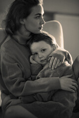  A black and white portrait of a mother and son in sweaters, embracing each other with smiles, radiating love and affection
