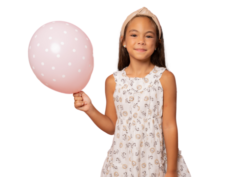Beautiful smiling child girl wearing a dress holding a pink balloon standing isolated over transparent background. PNG transparent.
