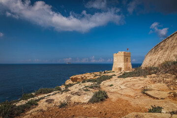 Torri Xutu. Ancient watch tower near Blue Grotto of Malta with Filfla island in a background. June 2023