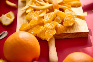 Freshly Cut Orange Slices on Cutting Board on Vibrant Red Background